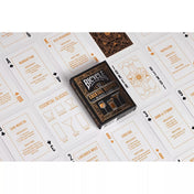 A Bicycle 52 Cocktail Recipes kártyapakli kirakott lapokkal, amelyeken koktélreceptek, hozzávalók és elkészítési útmutatók olvashatók, a középen elhelyezett dobozzal.
