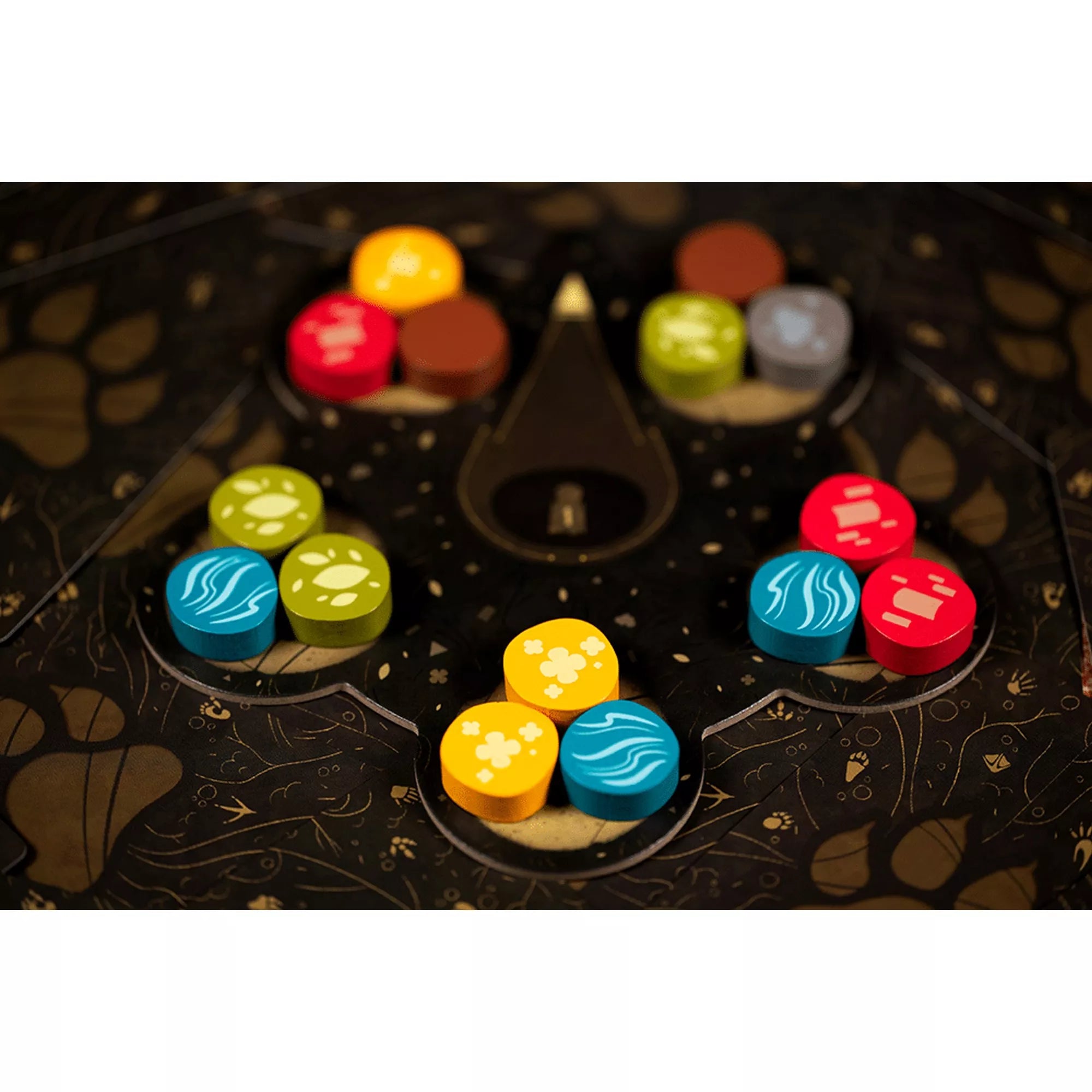 A Harmonies játék fakorongjai elrendezve a sötét játéktáblán, különböző szimbólumokkal.