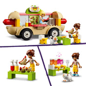 LEGO Friends jelenet: Kaya hot dogot szolgál fel a büfékocsiból Leónak, aki az asztalnál ül, mellette cica és ételes kiegészítők, valamint italadagoló állomás látható.