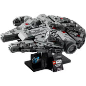 A LEGO Star Wars Millennium Falcon (75375) készlet összerakott hajója sötét kiállítóállványon, részletes kidolgozással, ikonikus kerek formával, szürke és sötétszürke elemekből, finoman elhelyezett piros díszítésekkel és a kiállítótáblán jól látható 25. évfordulós emblémával.