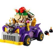 Az összerakott LEGO Super Mario Bowser izomautója (71431) látványos megjelenítése. A lila színű, erőteljes autó elején szúrós tüskék és egy ijesztő arc díszeleg, a volánnál pedig Bowser ül. Az autó mellett két kis fekete bombafigura (Bob-omb) is szerepel, fokozva az akciódús hangulatot.