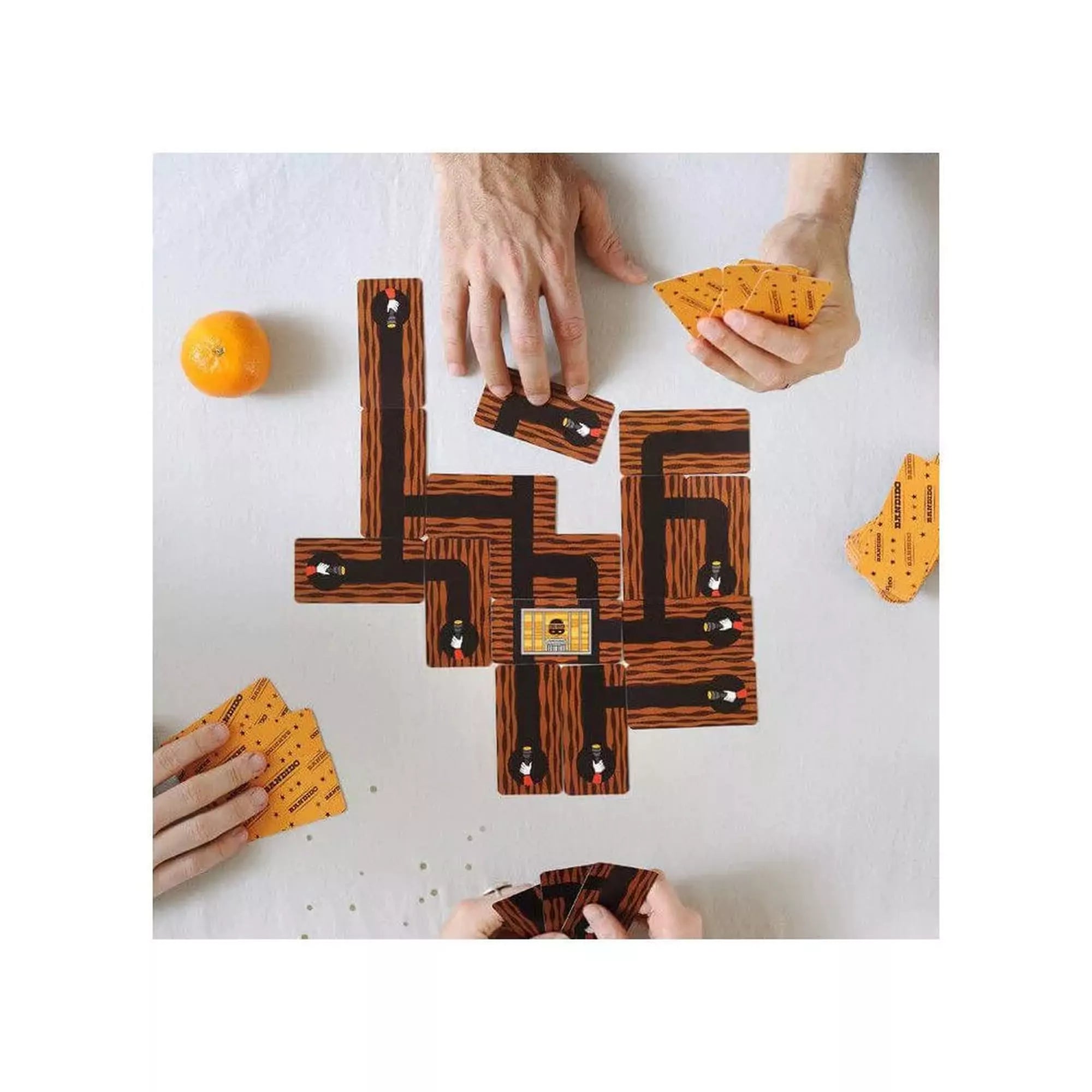 „A Bandido társasjáték játékmenete, ahol a játékosok kártyákból alagúthálózatot építenek az asztalon.”