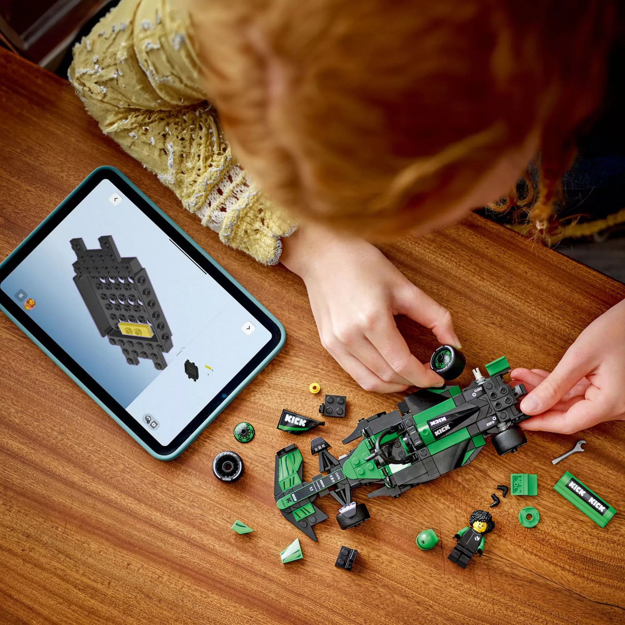 Gyermek építi a LEGO KICK Sauber F1 Team C44 versenyautót tabletről követett digitális útmutató segítségével.