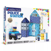 A MAGNA-TILES Police Station Set doboza, rajta a 35 darabos mágneses építőkészlet elemei: rendőrségi épület, járőr autó, két mágneses figura és fény- és hangmodul. A szett kék, áttetsző elemekkel, rendőrségi logóval és modern dizájnnal készült.