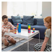 Egy kisfiú és egy kislány a Titkos Torony játékkal játszanak egy fehér asztalnál, miközben próbálják kitalálni a rejtett sorrendet.