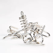 Fémből készült logikai játékok kupaca a 10 Metal Puzzle Set kék kiadásából, változatos mintázatú, fényes felületű drótformákkal, fehér háttér előtt.