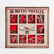 A 10 Metal Puzzle Set díszdoboza, amely piros háttérrel és retró stílusú barna kerettel emeli ki a tíz különböző formájú fém logikai játékot; a doboz elején kirakós darabokat ábrázoló ikonok és a Eureka! 3D Puzzle logó is látható.