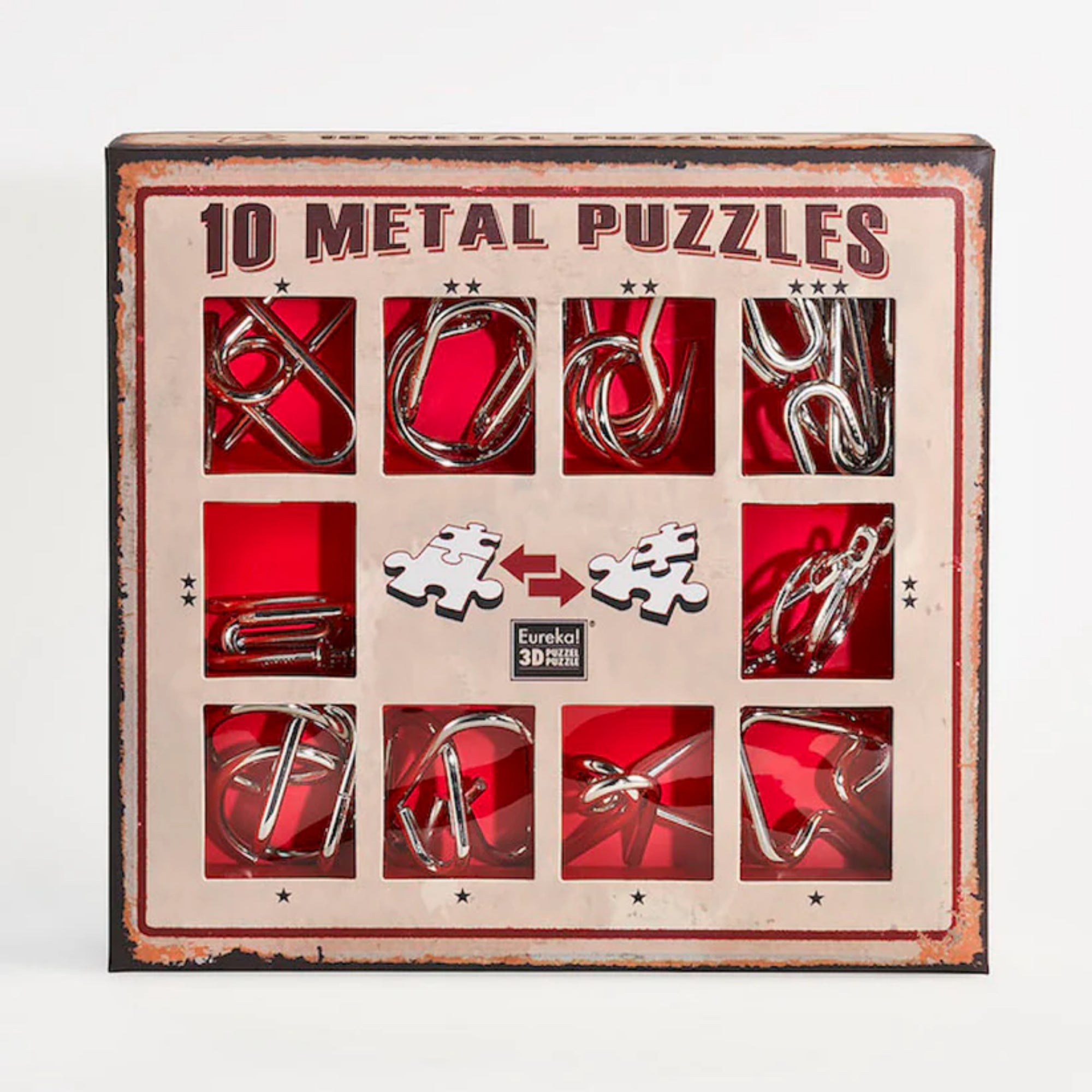 A 10 Metal Puzzle Set díszdoboza, amely piros háttérrel és retró stílusú barna kerettel emeli ki a tíz különböző formájú fém logikai játékot; a doboz elején kirakós darabokat ábrázoló ikonok és a Eureka! 3D Puzzle logó is látható.