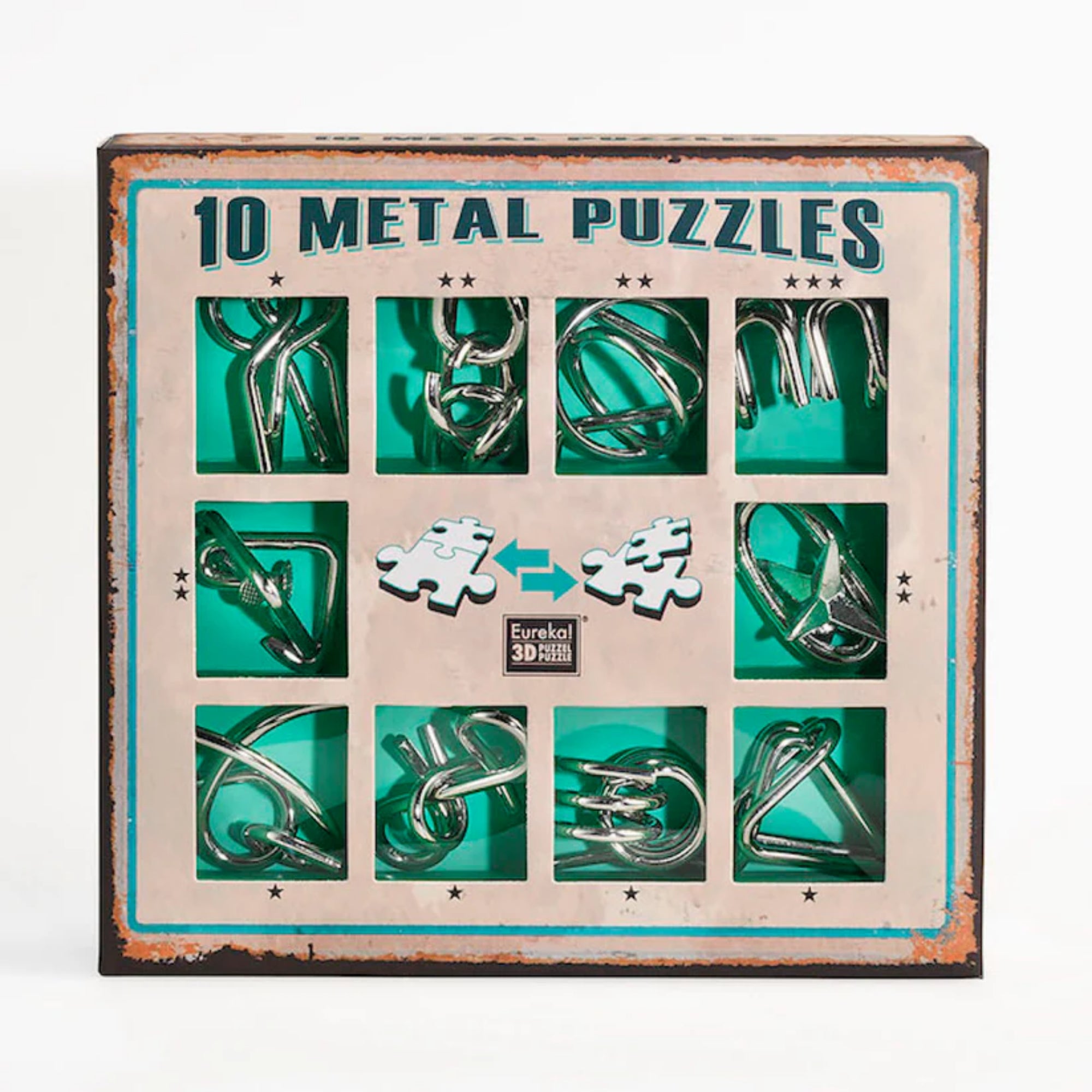 A 10 Metal Puzzle Set zöld változatának doboza elölről fotózva, amelyen tíz különböző fémből készült kirakó látható zöld háttérrel, rusztikus stílusú keretben, középen a „Eureka! 3D Puzzle” logóval.