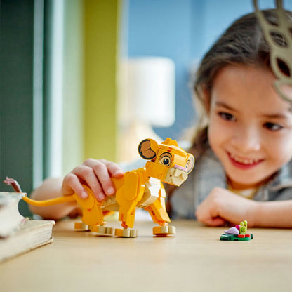 LEGO ǀ Disney Puiul Simba, Regele Leu - fata jucand cu figurina Simba