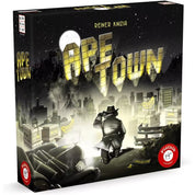 Ape Town társasjáték doboza, noir hangulatú városi háttérrel, amelyben egy detektív figyeli a fénnyel kiírt címet – egy izgalmas stratégiai játék Reiner Knizia tollából.