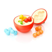 Az Apple Puzzler félbevágott, almát formázó logikai játék belseje látszik, benne különböző színes, kukac formájú puzzle-darabok, amelyek illeszkednek az alma belső formáiba.