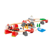 BRIO Smart Tech Sound Tűzoltó mentőállomás készlet elrendezve: A kiterített pályán tűzoltóvonat, égő tűz elemek, fa hidak és kiegészítők láthatók, Smart Tech Sound funkcióval kiegészítve.
