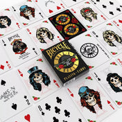 A Bicycle Guns N’ Roses kártyapakli doboza különböző kirakott lapok között, melyeken a zenekar tagjait koponyafiguraként ábrázoló illusztrációk és a híres logó látható.