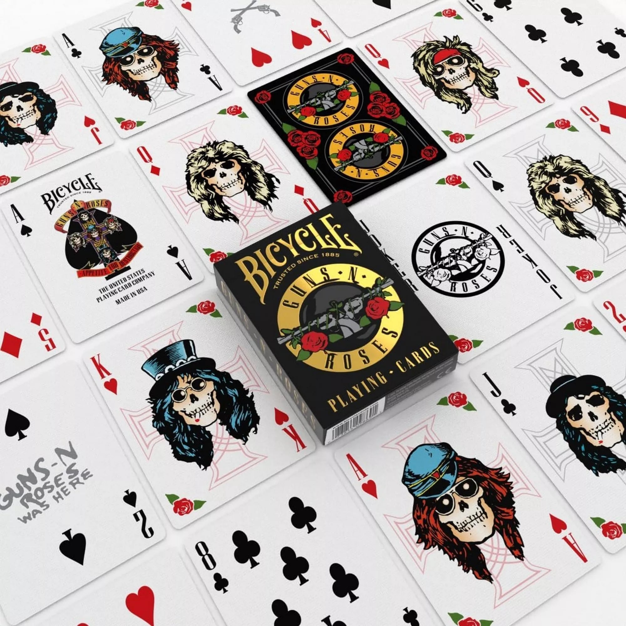 A Bicycle Guns N’ Roses kártyapakli doboza különböző kirakott lapok között, melyeken a zenekar tagjait koponyafiguraként ábrázoló illusztrációk és a híres logó látható.