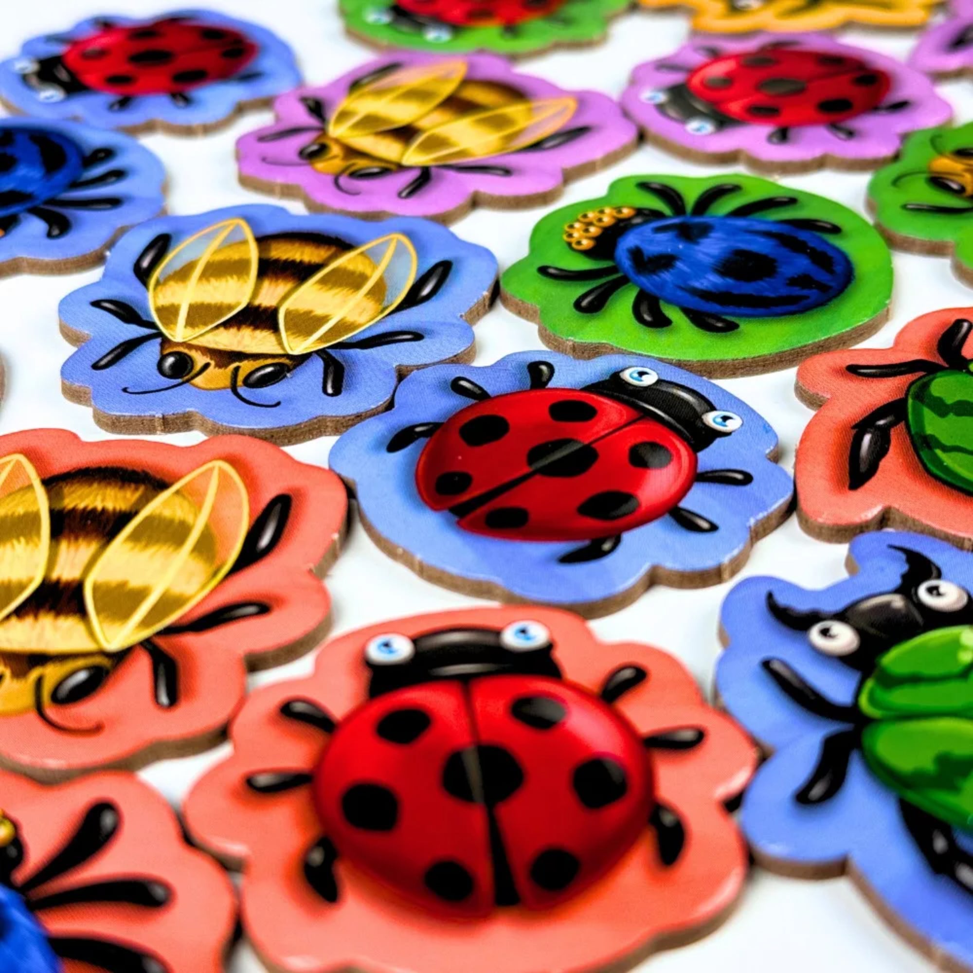 Bogártánc társasjáték fa rovarfigurái közelről, virág alakú lapkákon katicákkal és méhekkel.