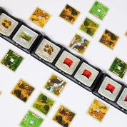 A képen a "Catan: A párbaj" kártyajáték játékelemei láthatóak amelyek stilusos elrendezéssel jelennek meg. A kártyák, amelyeken különböző településeket, erőforrásokat és egyéb fontos elemeket találunk, stratégiai döntések meghozatalára szolgálnak.
A kártyákon a barna, zöld és vörös szín dominál. 