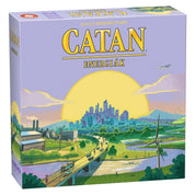A képen a "Catan: Energiák" társasjáték indigo színű doboza látható. A doboz borítóján egy modern városképet látunk, amely szélkerékkel, napelemekkel és ipari létesítményekkel van díszítve, ezzel utalva a fenntartható energiákra.