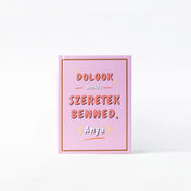 „Dolgok, amiket szeretek benned, Anya” kitölthető ajándékkönyv rózsaszín borítója, dekoratív felirattal és minimalista dizájnnal, fehér háttéren bemutatva.