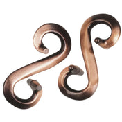 Két különálló, patinás réz színű, csavart formájú fémdarab – Huzzle Cast S&S puzzle elemei szétszedett állapotban.