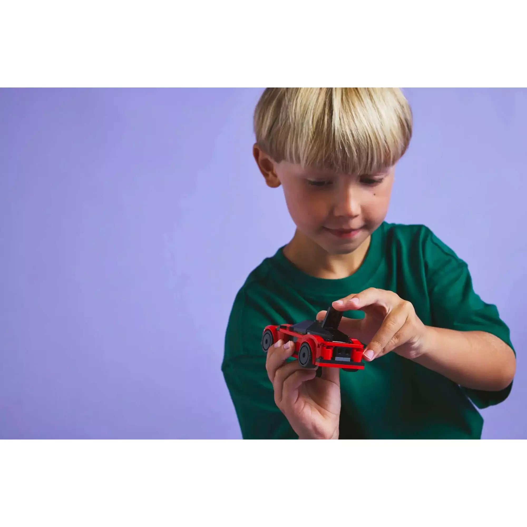 Egy gyermek játszik a LEGO CITY Piros sportautóval (60448), miközben felfedezi a lenyitható csomagtartót és az elegáns kialakítást