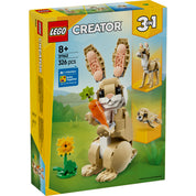 A LEGO Creator Aranyos Nyuszi 31162 készlet dobozának képe, amely bemutatja a felépített nyuszimodellt egy répával, mellette kisebb képekkel a két másik lehetséges modellel: egy láma és egy fóka. A háttérben természetes tájat láthatunk, ami a játék természetközeli hangulatát erősíti meg.