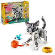 A LEGO Creator 3 az 1-ben Játékos Macska 31163 doboza és az összeállított macska modell, akit egy játék egérrel és egy etetőtálkával láttak el. A háttérben a dobozon látható a további két építhető modell: egy kutya és egy galamb.