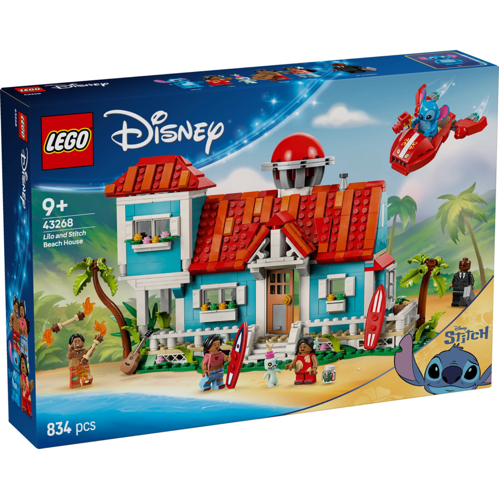 A képen a LEGO Disney Lilo és Stitch Tengerparti Háza (43268) készlet látható. Ez a színes, részletgazdag építőjáték egy ikonikus kék-fehér tengerparti házat ábrázol, piros tetővel és számos, a filmre jellemző elemmel. A doboz grafikája egy festői trópusi hátteret mutat, ahol Stitch egy piros űrhajóval repül, míg Lilo és családja a ház körül játszanak és pihennek. A készletben megtalálhatóak a népszerű szereplők, köztük Lilo, Stitch, Nani, David és Mr. Bubbles minifigurái, valamint extra kiegészítők, mint a