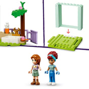 Négy külön illusztráció mutatja be a LEGO Friends 42617 készlet részleteit: egy gyümölcslé standot Ben és Aliya minifigurával, egy piros utánfutós traktort zöldségekkel, egy forgó szélmalmot, valamint jeleneteket, ahol a szereplők háziállatokkal játszanak és etetik őket – a gazdag játéklehetőségek kiemelésével.