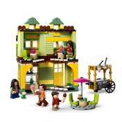 A LEGO Harry Potter 76452 készlet sárga-zöld fagyizójának belső tere, színes bútorokkal, fagylaltos kocsival és három minifigurával.
