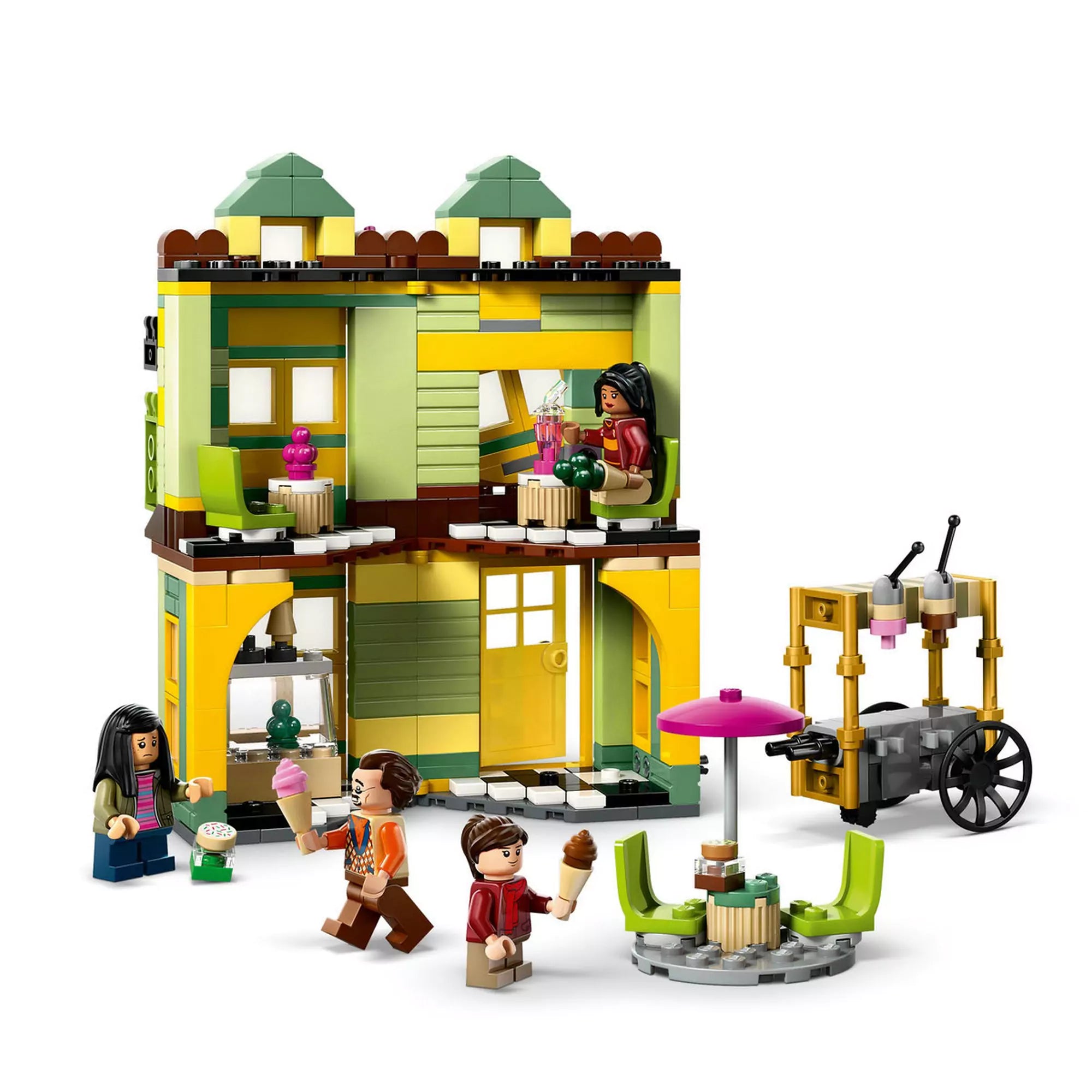A LEGO Harry Potter 76452 készlet sárga-zöld fagyizójának belső tere, színes bútorokkal, fagylaltos kocsival és három minifigurával.