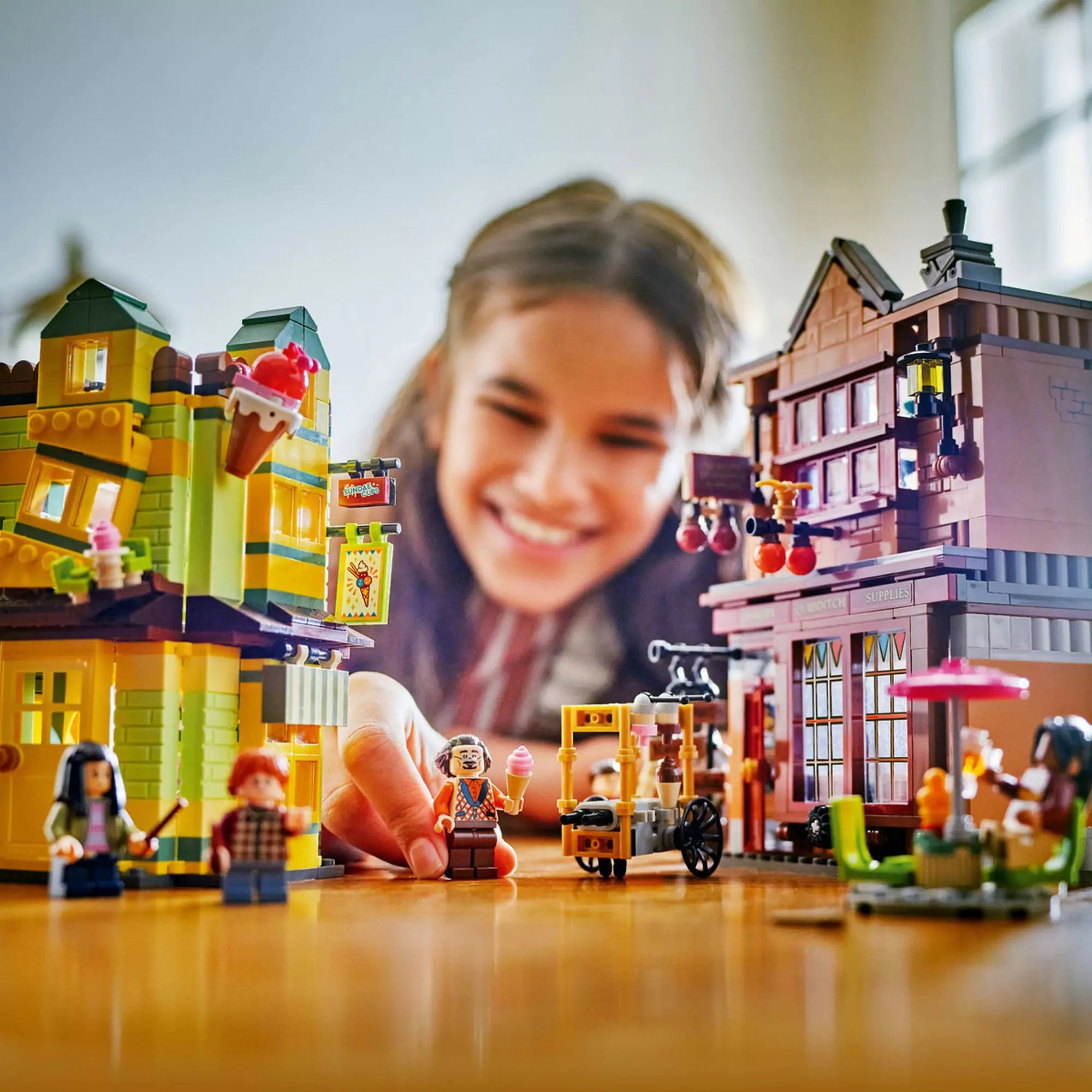 Egy kislány játszik a LEGO Harry Potter 76452 készlet teljes jelenetével, amely tartalmazza a Quidditch boltot, a fagylaltozót és több karaktert is.