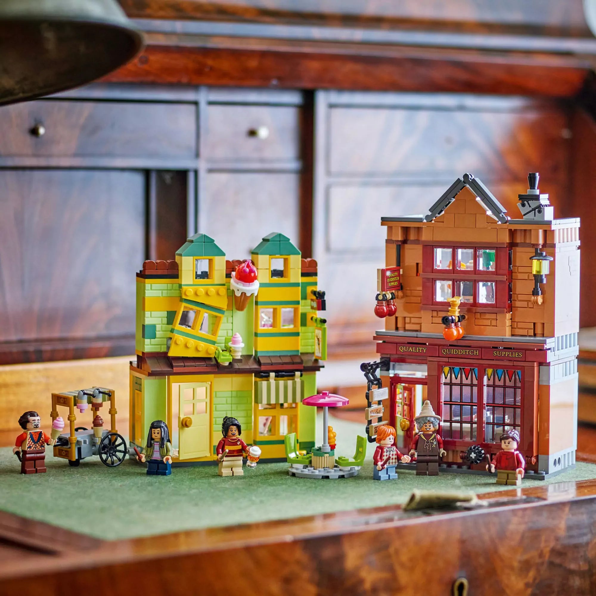 A LEGO Harry Potter 76452 készlet két fő épülete kiállítva – a Quidditch felszerelés boltja és a fagylaltozó, minifigurákkal és kiegészítőkkel.