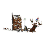 A LEGO Harry Potter Szellemszállás és Fűzfa (76407) készlet teljes tartalma, benne a két összekapcsolt épület, a varázslók szállása és a Szúrós fűz, minifigurákkal és kiegészítőkkel elrendezve.