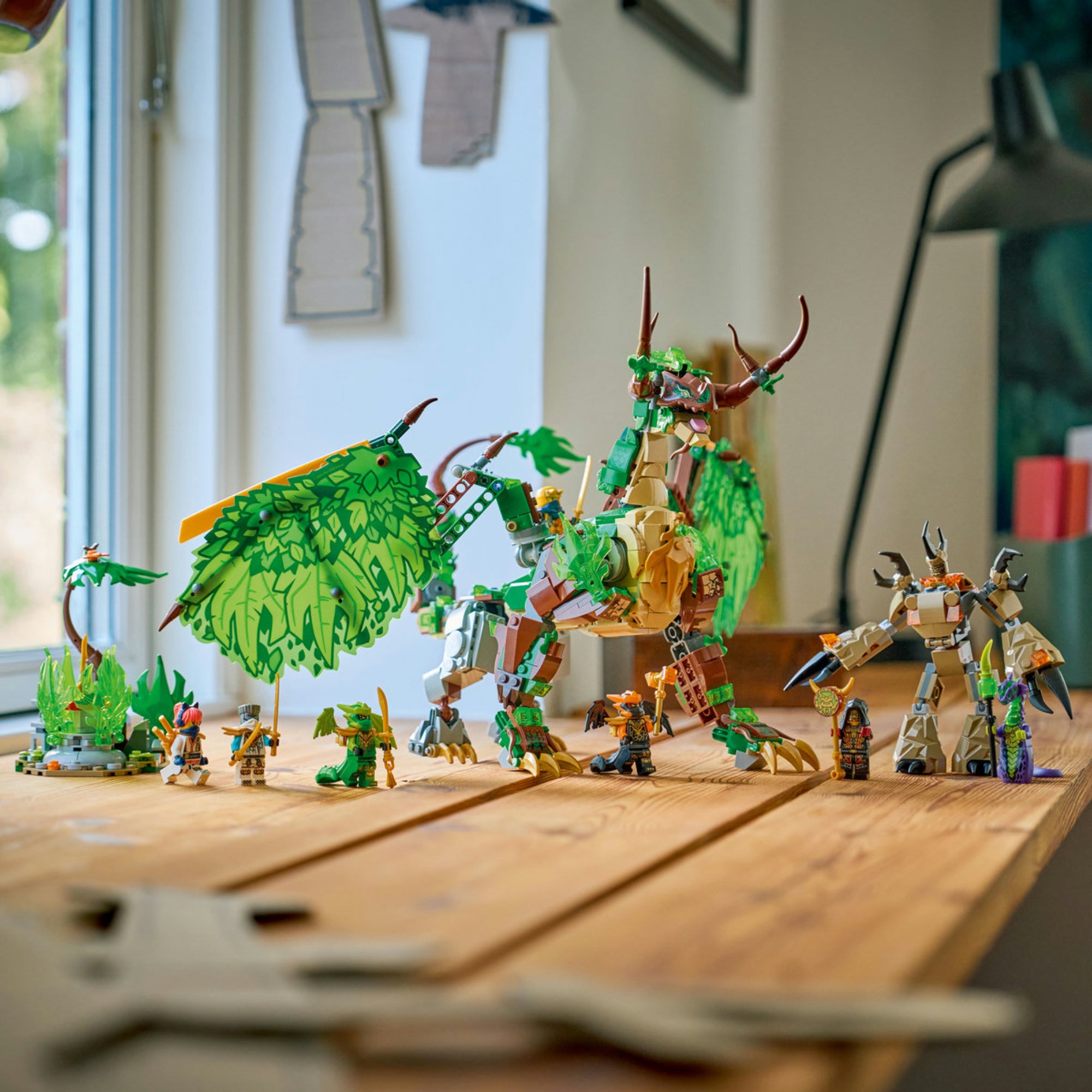 LEGO NINJAGO The Dragon of Life (71859) megépített zöld sárkány modell minifigurákkal asztalon kiállítva.