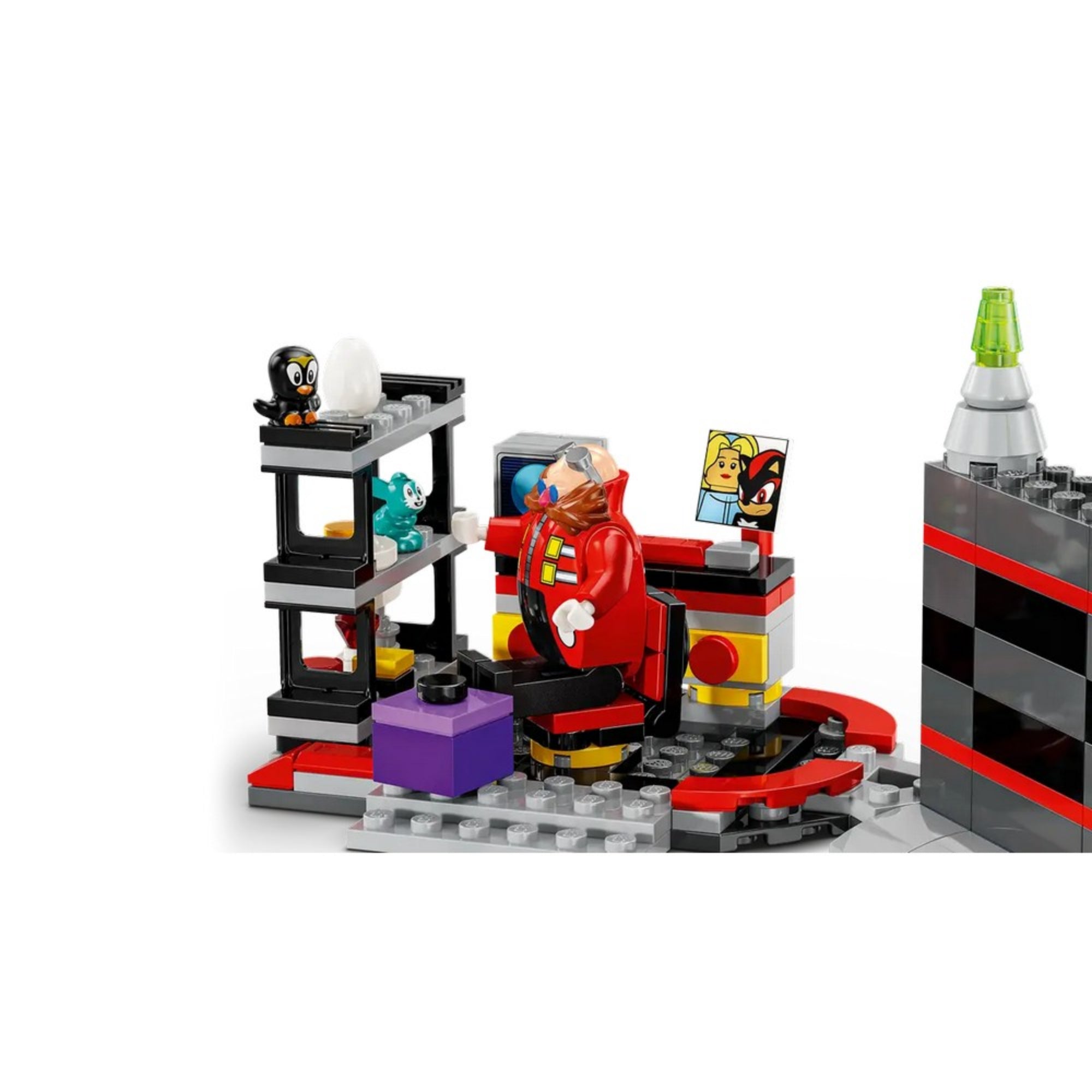 Dr. Eggman laborja közelebbről, kis állatokkal ketrecben, irányítófallal és képernyővel, amin Shadow és egy női karakter képe látható.