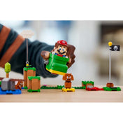 Közelkép a LEGO Super Mario Goomba cipője (71404) játékról, ahol a Mario figura a zöld cipőben ül, és épp a Goombát próbálja eltalálni.