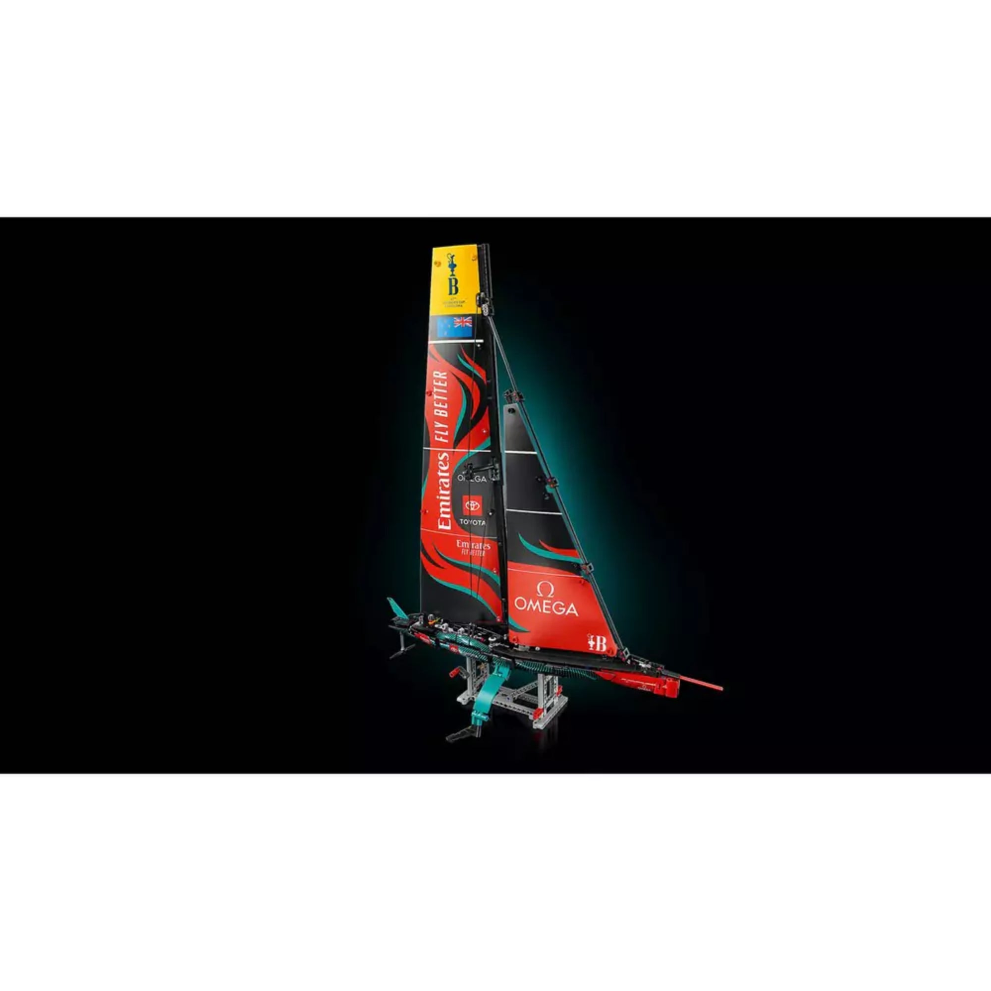 A LEGO Technic Emirates Team New Zealand AC75 jacht (42174) megvilágított modellje sötét háttér előtt, kiemelve a vitorla részleteit és szponzori logókat.