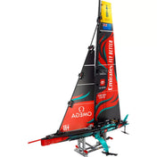 A LEGO Technic Emirates Team New Zealand AC75 vitorlás jacht (42174) teljesen összeszerelt modellje fekete-piros vitorlákkal és részletes hajótesttel, bemutató állványon.