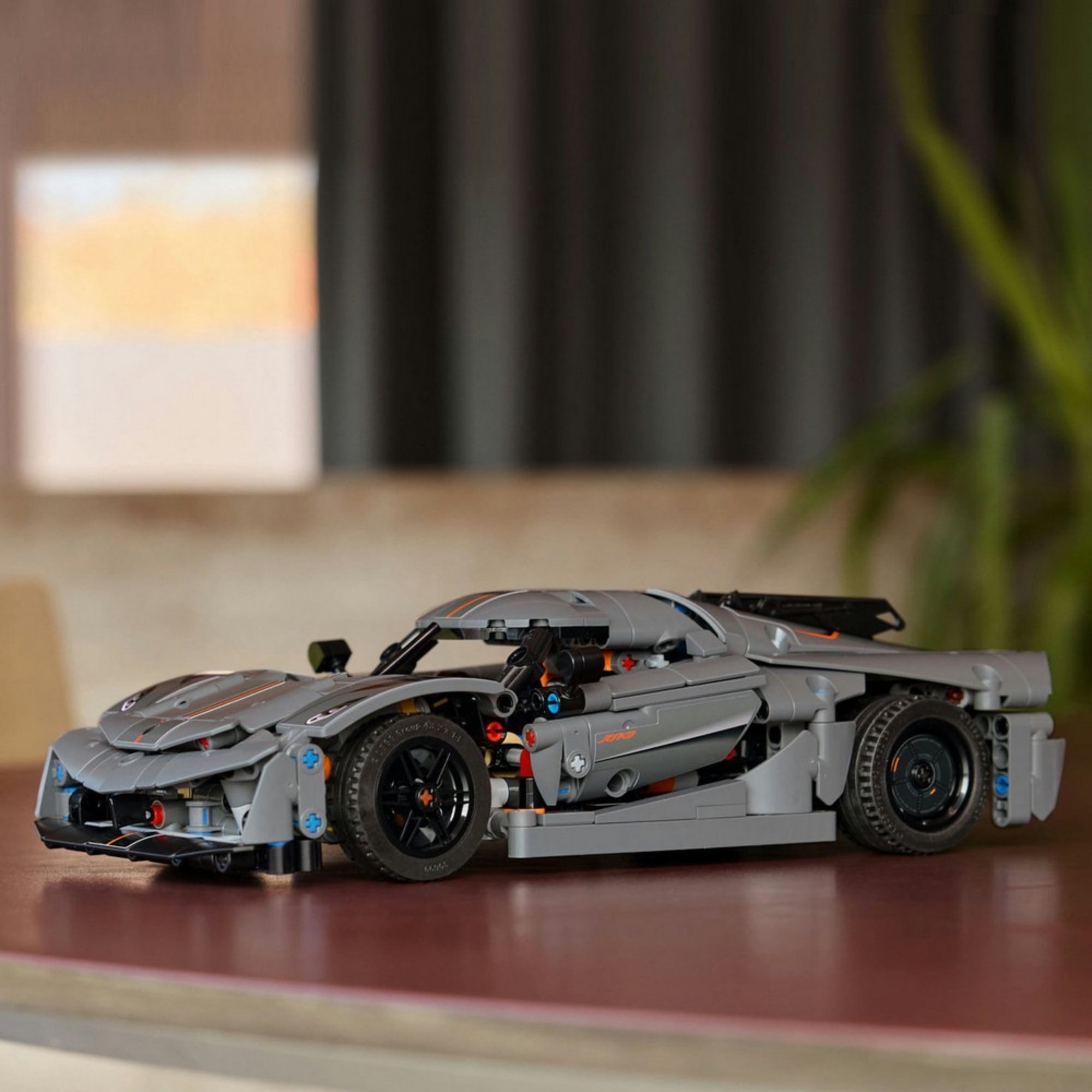A LEGO Koenigsegg Jesko modell kiállítva egy modern, letisztult lakásban, kiemelve a sportautó elegáns íveit és realisztikus kerekeit.