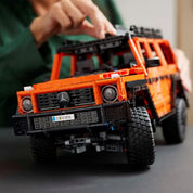 LEGO Technic Mercedes-Benz G 500 PROFESSIONAL Line eleje, pirosas-narancssárga kasztnival, realisztikus hűtőráccsal és fényszórókkal, építés közbeni jelenetben.