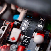 Részletgazdag makrófelvétel a LEGO Technic Mercedes-Benz G 500 PROFESSIONAL Line sebességváltójáról és hajtáslánc kapcsolóiról, jól olvasható „RND” és „LO/HI” jelölésekkel.