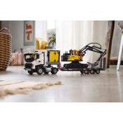 Összeépített LEGO Technic Volvo FMX teherautó és EC230 markoló egy nappaliban elhelyezve, természetes fény mellett.