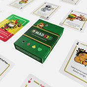 „MAD420 kártyajáték doboza asztalon, körülötte humoros grafikájú feladatkártyákkal.”
