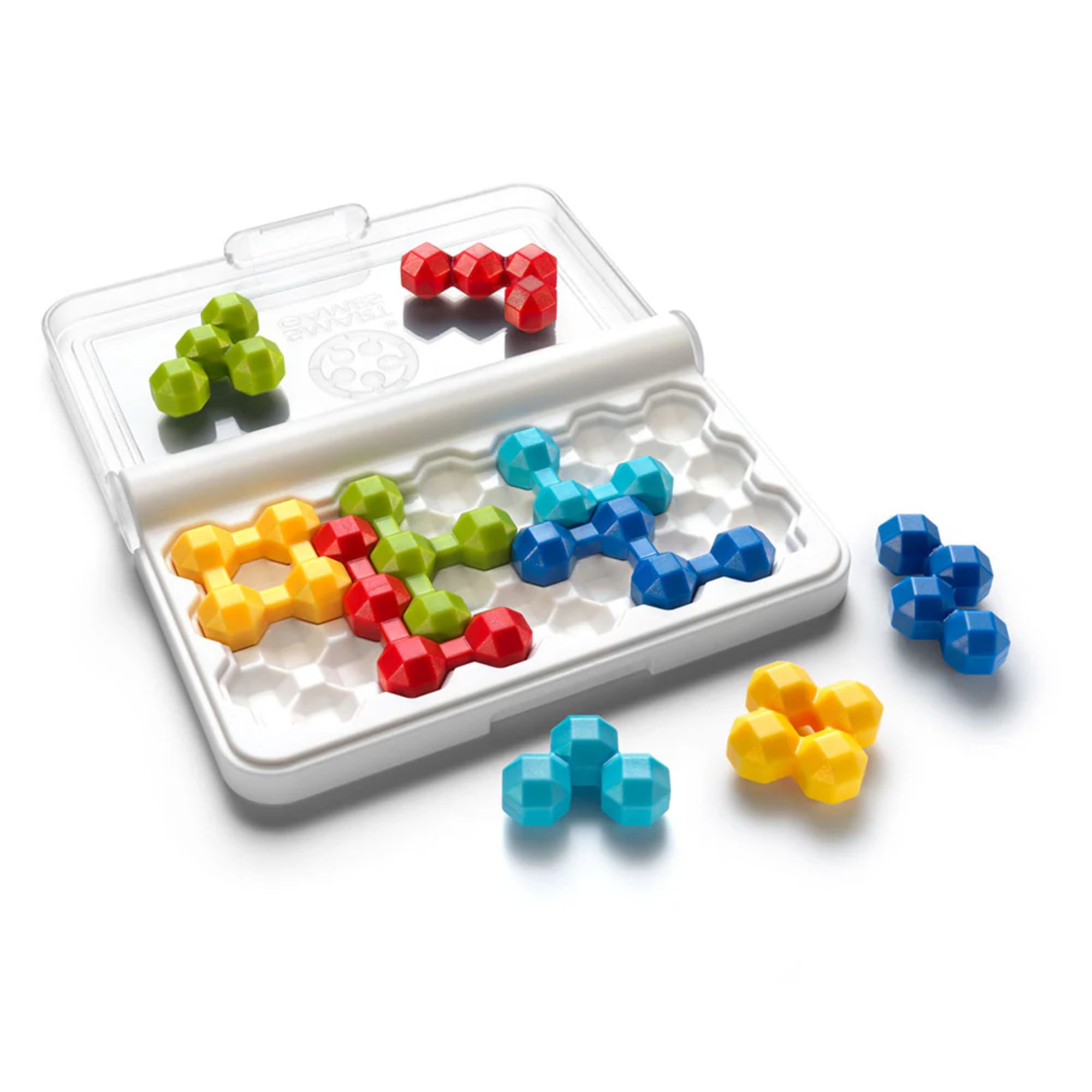 A képen a Smart Games IQ Twins logikai játék belső tartalma látható közelebbről. A fehér, zárható tok nyitott állapotban van, és jól látszanak benne a hatszög alakú mélyedések, amelyekbe a különböző színű, háromdimenziós puzzle-elemek illeszkednek. A játék darabjai élénk színűek (piros, zöld, sárga, kék, világoskék), és mindegyik forma egyedi kialakítású, mégis párban szerepelnek – de nem teljesen egyformák! 