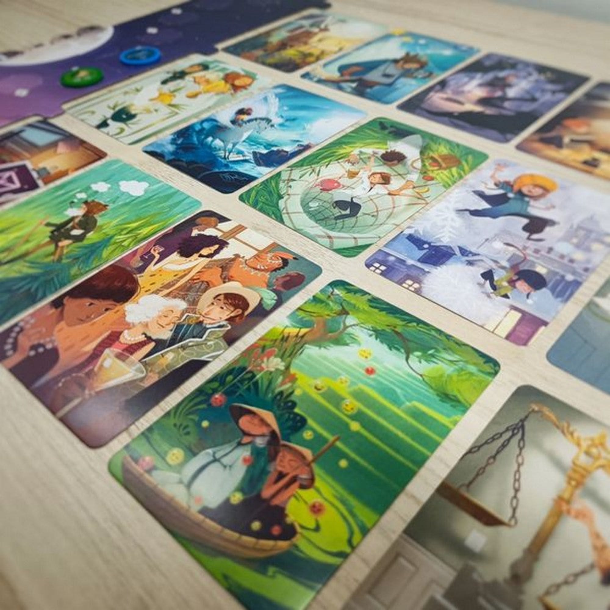A Stella: Dixit Universe társasjáték kártyáinak közelképe, amelyeken különleges, fantáziadús illusztrációk láthatók. A színes kártyákon mesés jelenetek és részletgazdag grafikák jelennek meg, amelyek a játék kreatív és történetmesélős hangulatát erősítik. A háttérben további játékelemek és kártyák sejlenek fel.