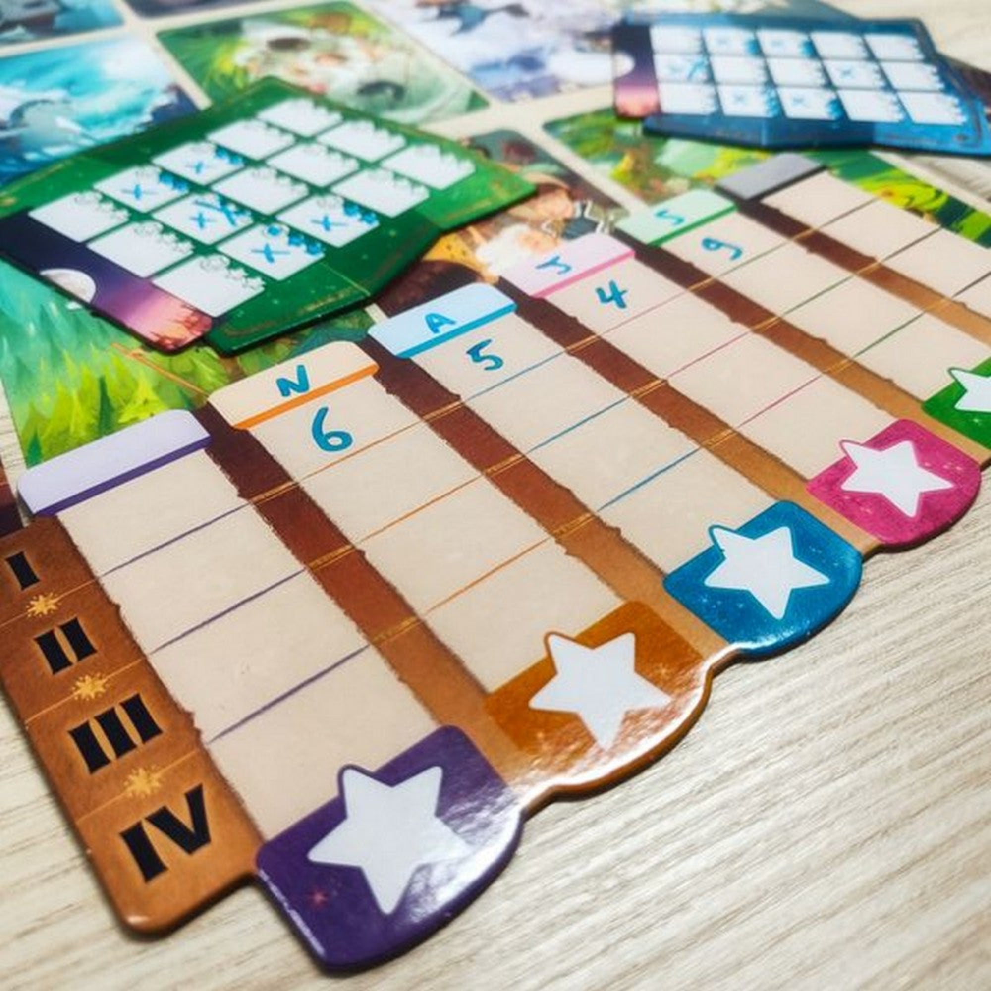 A Stella: Dixit Universe társasjáték pontozótábláinak közelképe, amelyeken színes csillagok és oszlopok láthatók, a játékosok pontszámainak nyomon követésére. A háttérben további játékkártyák és komponensek láthatók, amelyek a játék kreatív és vizuálisan lenyűgöző jellegét tükrözik.