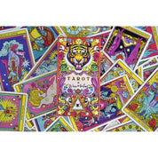 Ez a kép az „El Dios de los Tres” tarot kártyapaklit mutatja, színes, dinamikus elrendezésben. A középpontban a tigrisfejes doboz látható, amelyet élénk színű, pszichedelikus stílusú tarot lapok vesznek körül. A kártyák illusztrációi tele vannak misztikus szimbólumokkal, csillagokkal, szemekkel, mitikus lényekkel és vibráló mintákkal. A pakli erőteljes vizuális világot közvetít – egyszerre spirituális, vad és merész.