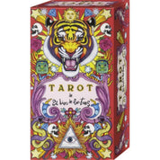Ez a kép az „El Dios de los Tres” tarot pakli szemet gyönyörködtető dobozát ábrázolja, melyen egy tigris dominál, élénk, pszichedelikus színekkel körülölelve. A doboz központi eleme a haragos tigrisfej, fölötte egy nap arc és csillagok, körülötte koponyák, színes kígyók, ékszerek és egy szemmel ellátott háromszög szimbólum is látható. A doboz látványos, részletgazdag illusztrációi spirituális és misztikus jelentéseket idéznek. 