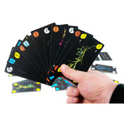 Tricky Twist játékkártyák kézben tartva, számozott és színes szimbólumokkal